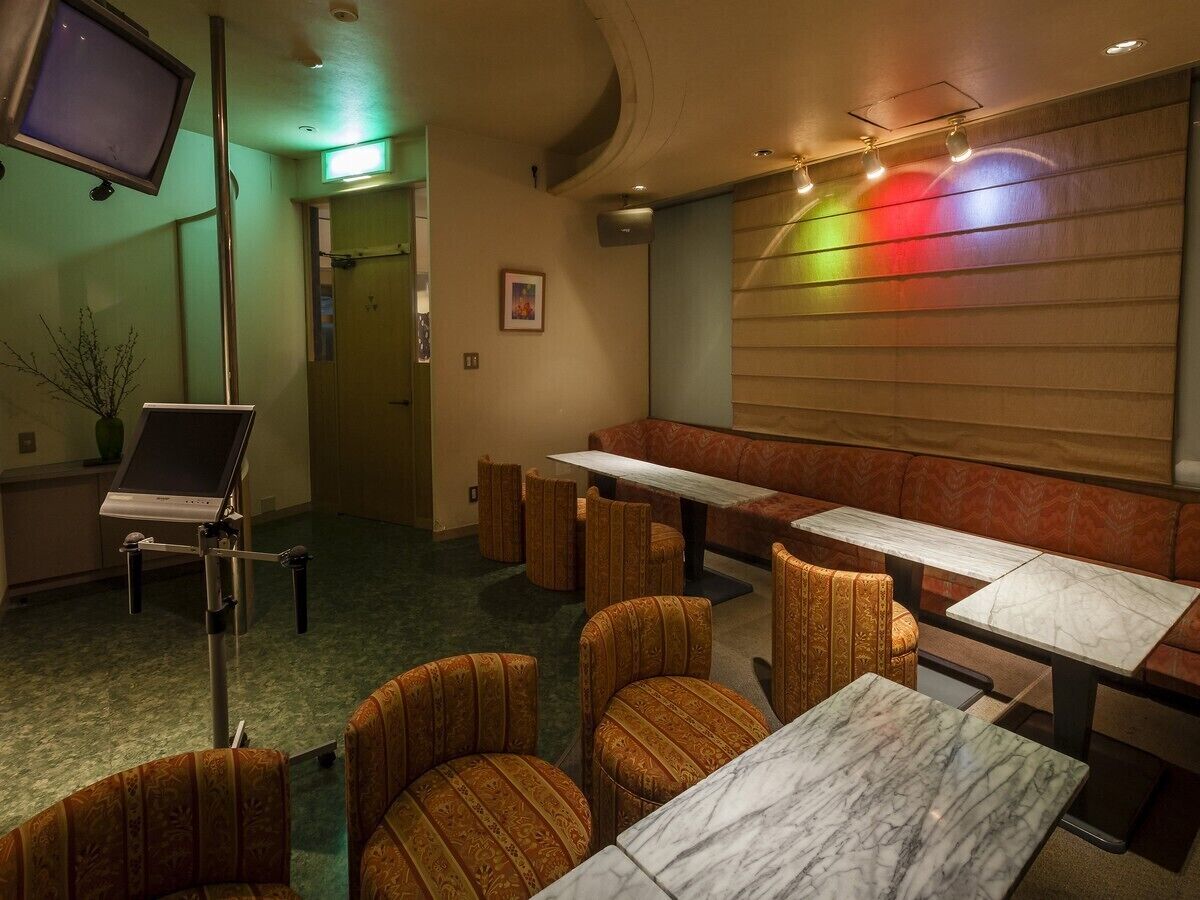 A restaurant with booths and tables, a television, and a piano.