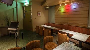 A restaurant with booths and tables, a television, and a piano.