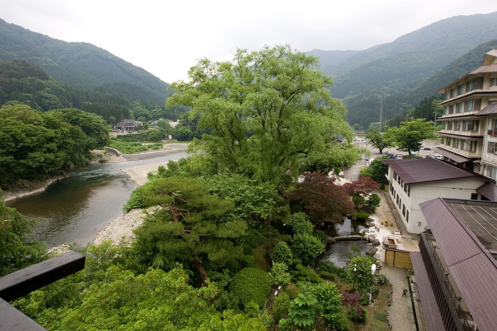 A traditional Japanese building with a view of a river and mountains.