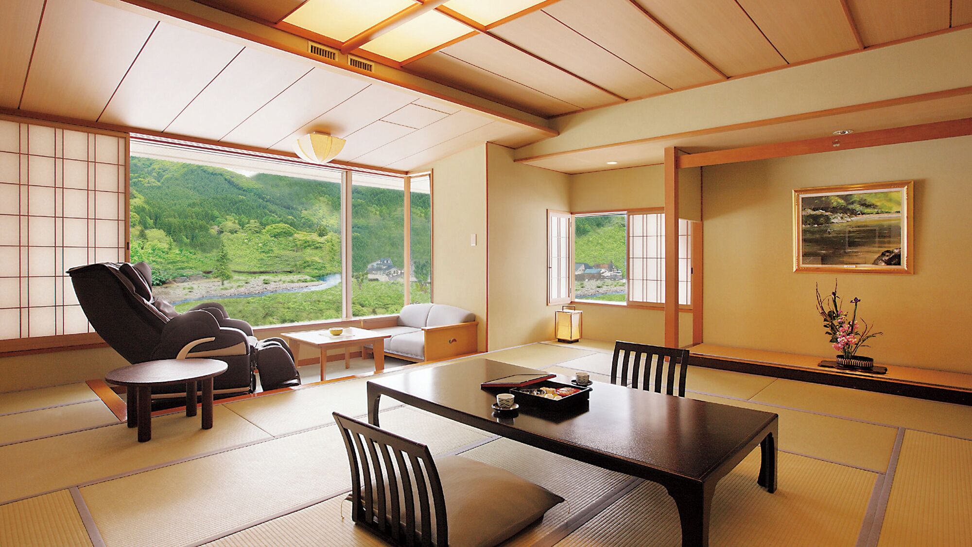 Une pièce de style japonais traditionnel, avec un sol recouvert de tatamis, une table basse, des chaises, un canapé et de grandes fenêtres donnant sur une zone boisée.
