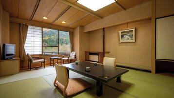 A traditional Japanese-style room with tatami flooring, a low table, and chairs.