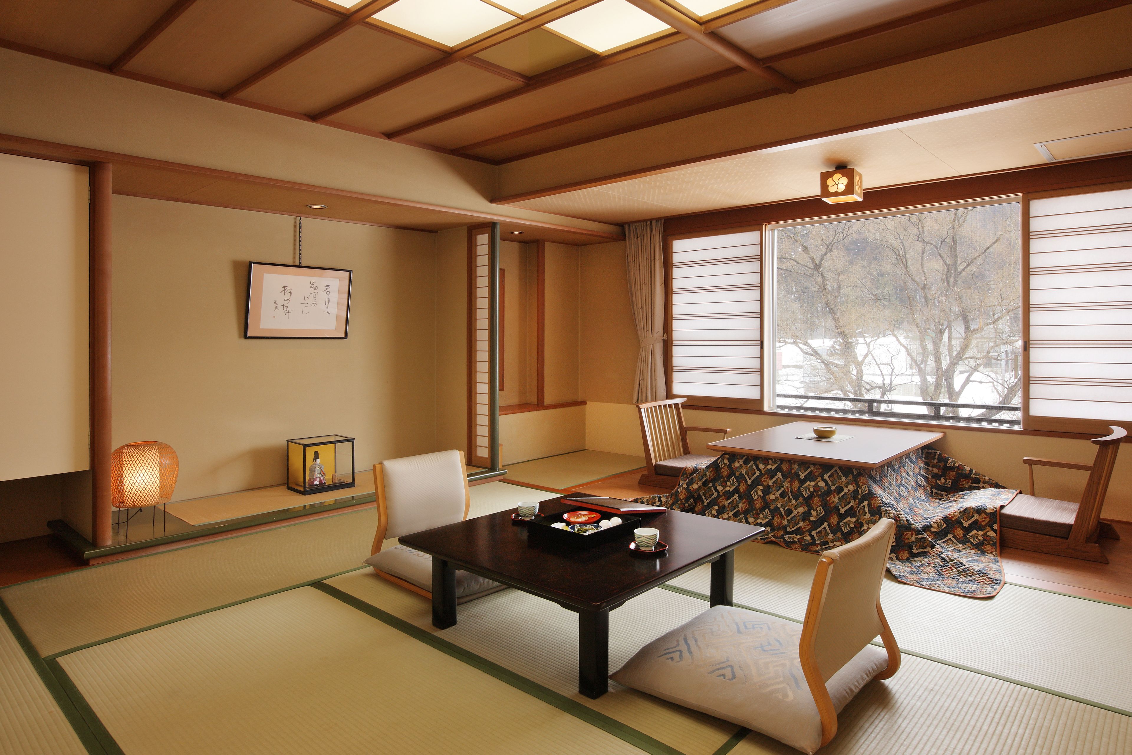 A traditional Japanese room with tatami flooring, a low table, and a sliding door.