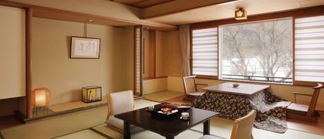 A traditional Japanese room with tatami flooring, a low table, and a sliding door.