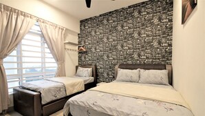 Un dormitorio con dos camas, una ventana con cortinas, una pared con el texto 'LOVE' repetido y una lámpara colgante.