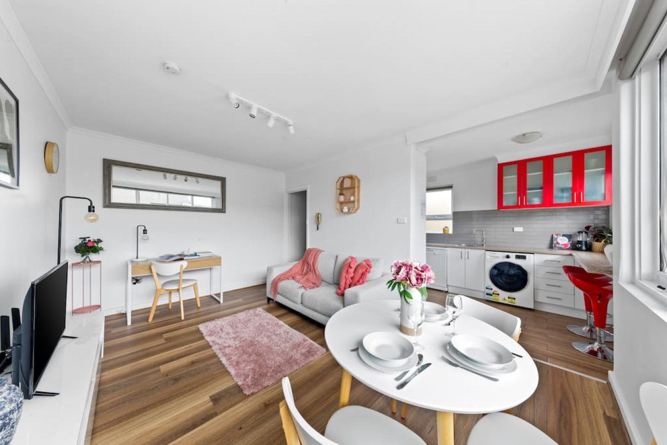 A modern apartment with a dining area, kitchen, and living space.