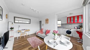A modern apartment with a dining area, kitchen, and living space.