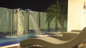 A pool area with lounge chairs and a palm tree. - H2H Euro House (Ipoh)