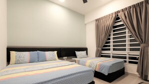 A bedroom with two beds, a window with curtains, and a headboard.