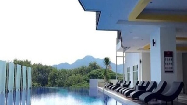 A pool area with lounge chairs and a view of mountains. - H2H Maison De Luxe (Ipoh)