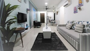 Una sala de estar moderna con sofá, televisor y ventiladores de techo.