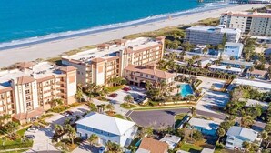Un hôtel situé sur la côte, composé de plusieurs bâtiments, doté d’un parking et d’une piscine.