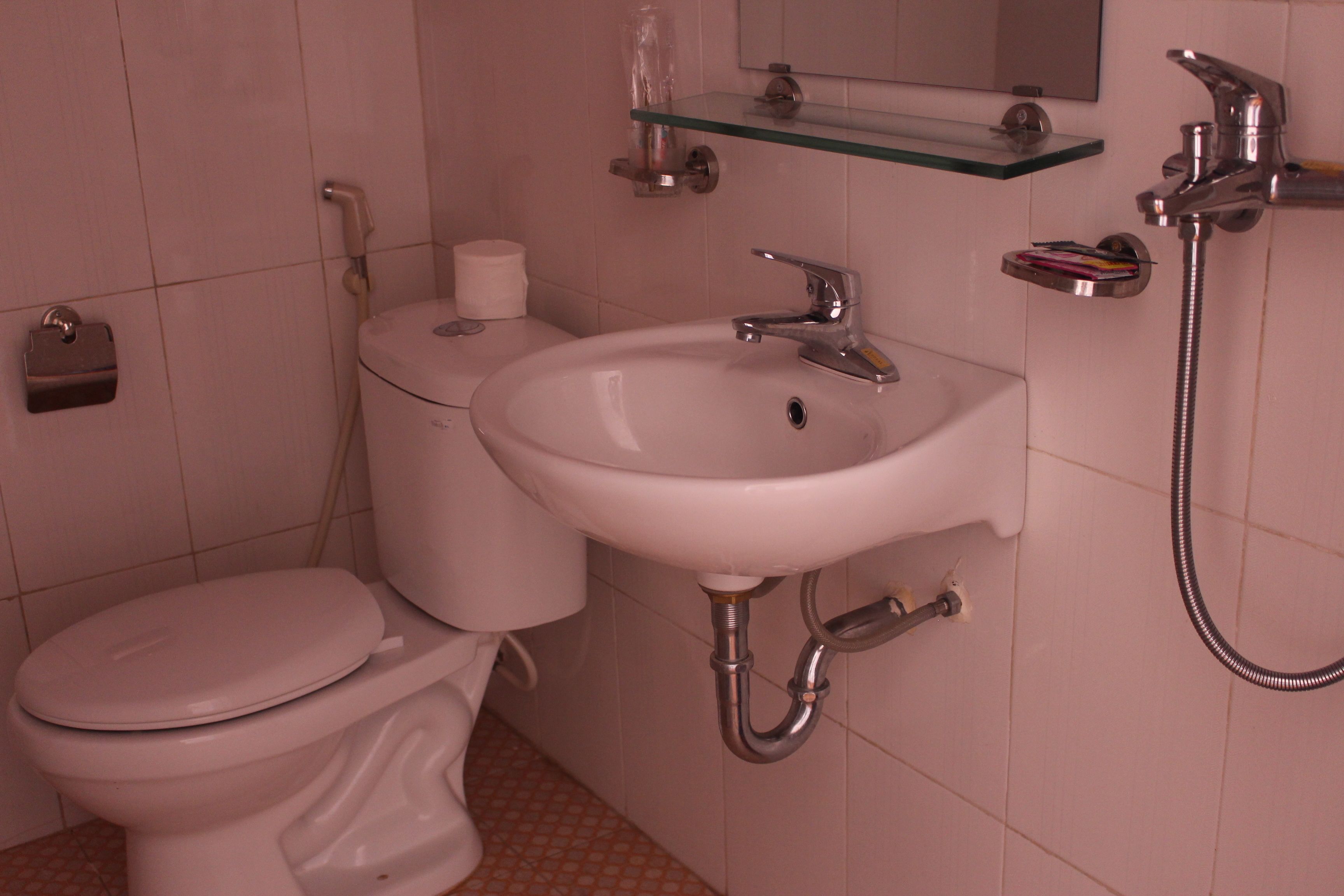 A bathroom with a toilet, sink, and shower.