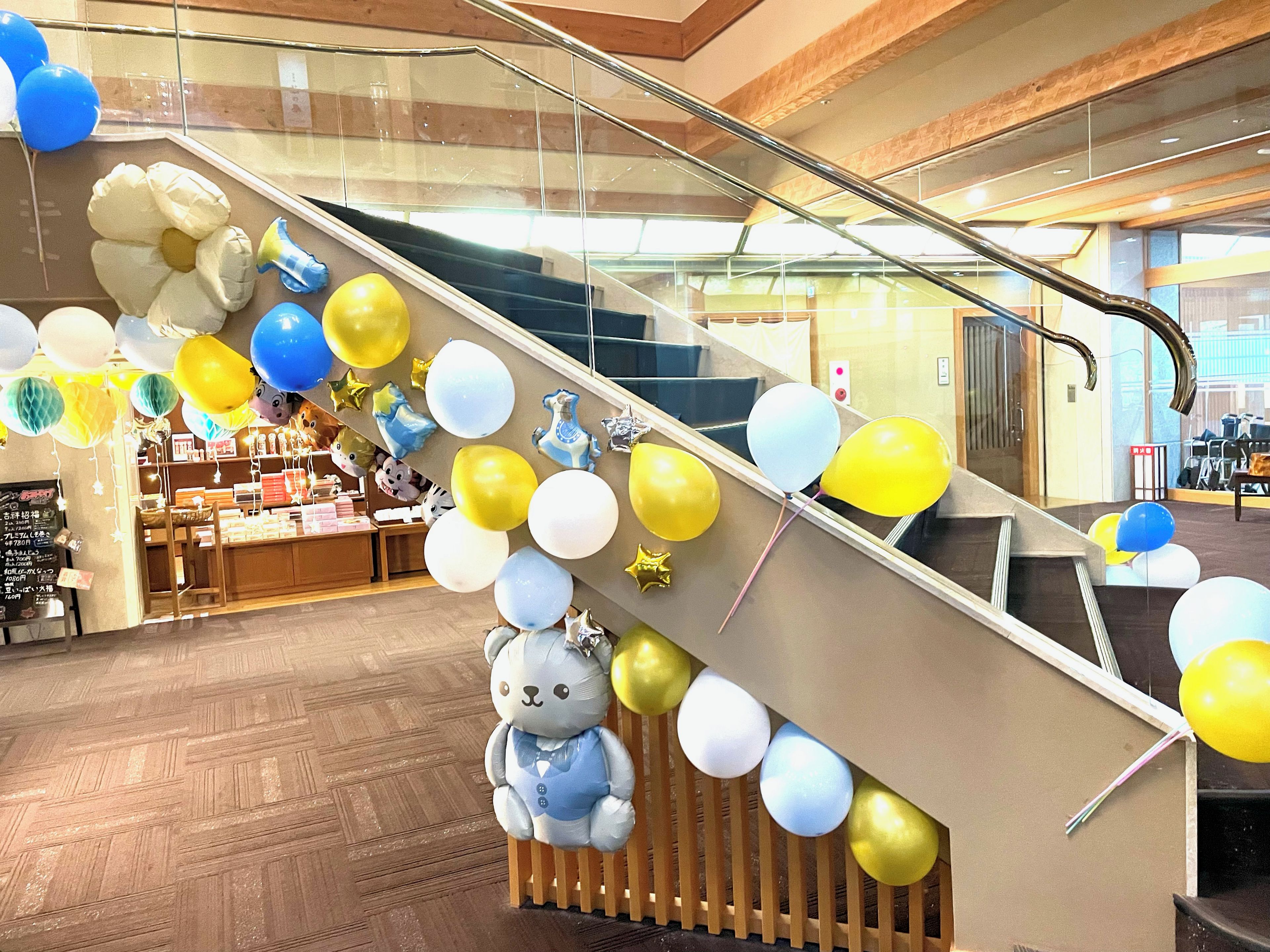 An indoor space with a staircase, wooden flooring, and a display area with various items.