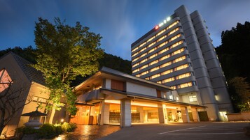Un hotel de diseño moderno, con un edificio grande de varios pisos y una entrada destacada.