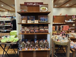 Una exhibición de alimentos con diversos productos envasados y un cartel arriba.