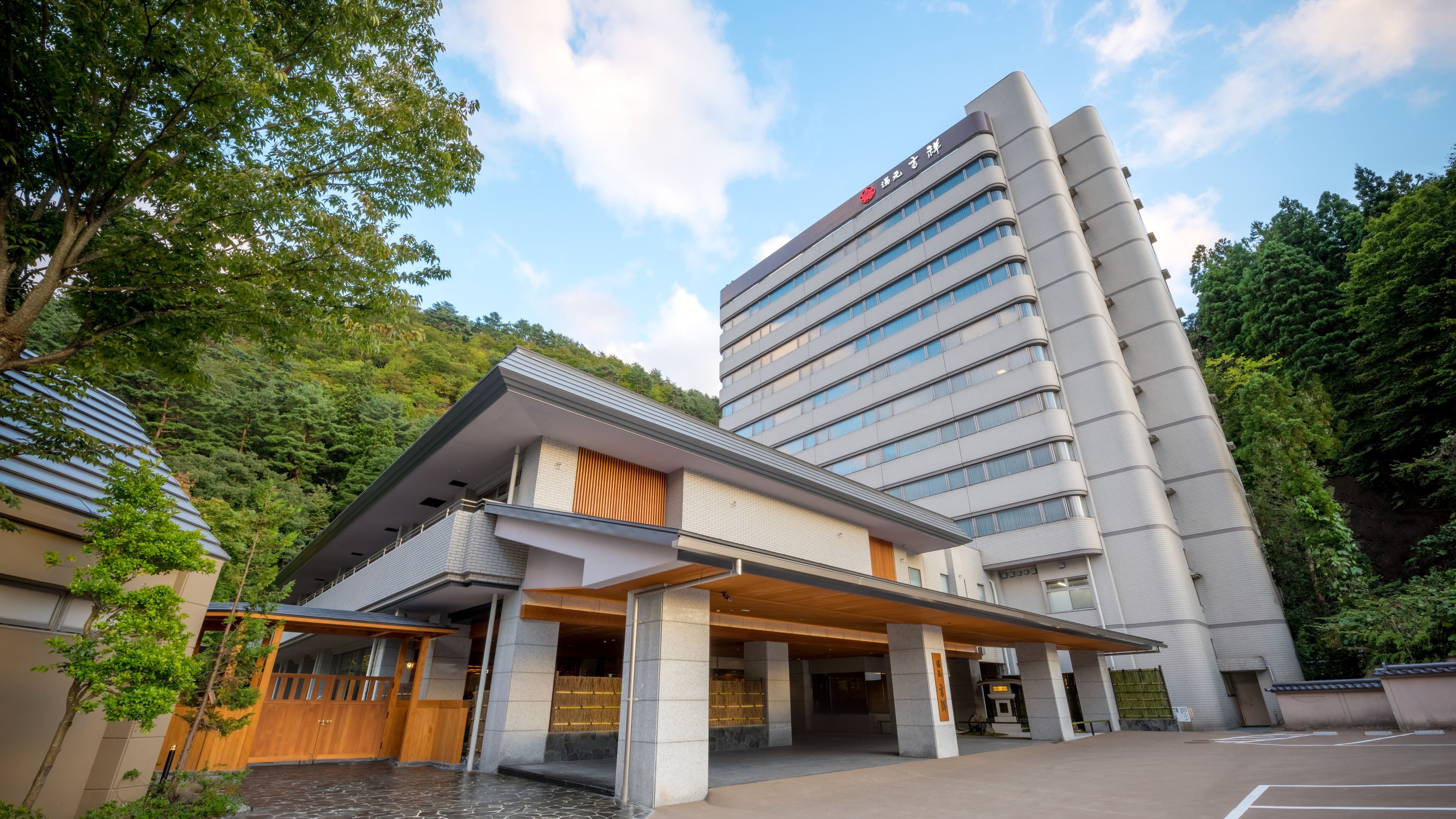 Un hotel moderno con un edificio de varios pisos y un área de entrada techada.