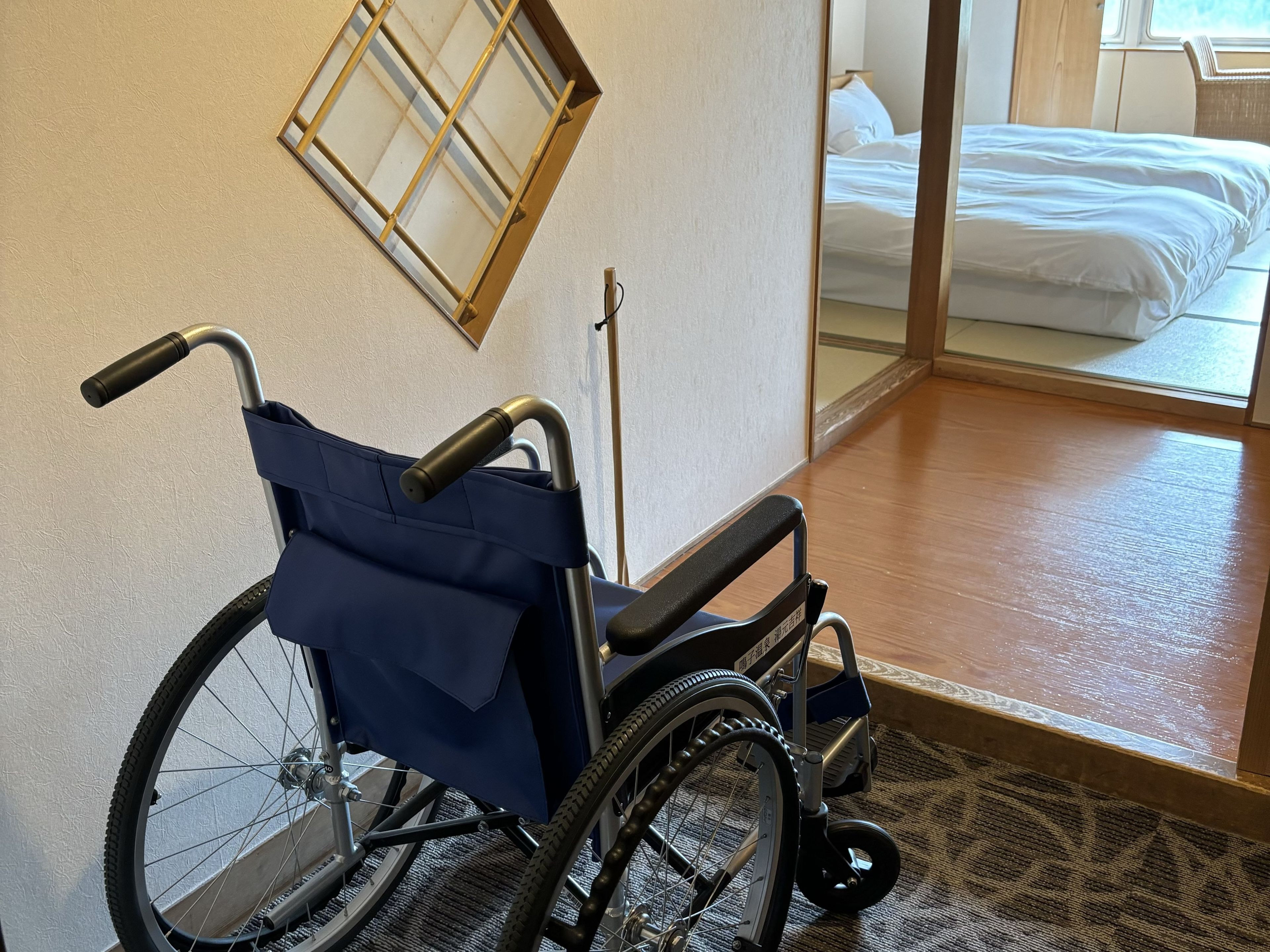 A wheelchair in a room with a bed and a window.