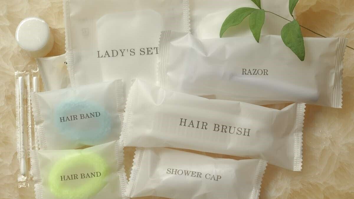 Un conjunto de artículos de aseo personal, incluyendo un rastrillo de afeitar, un cepillo para el cabello y un gorro de ducha.