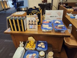 Mostrador con diferentes alimentos y bebidas, incluyendo bebidas envasadas, salsas y aperitivos.