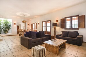A spacious living room with two sofas, a coffee table, and a dining area with chairs and a table.