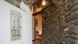 A staircase leading to a bedroom with a stone wall and a framed picture of a sailboat on the wall. - Unda de Ma Apartment with AC & Sea View Balcony (Vernazza)