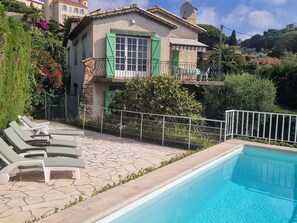 A poolside area with lounge chairs and a swimming pool. - Sea view villa with pool and shady garden, quiet location  (Vallauris)