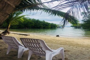 En la playa, sombrillas, bote de remos