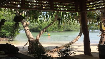 En la playa, sombrillas y bote de remos o canoa