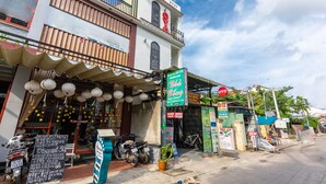 A street view with a building that has a sign for a restaurant and a sign for a hotel. - Bong House Homestay Hoi An (Da Nang)
