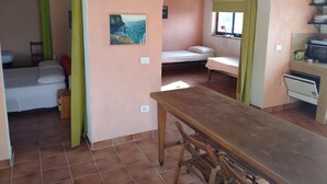 A compact room with a bed, a small table, and a kitchenette.