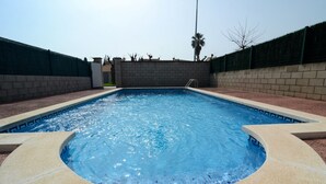 Una piscina rectangular con borde de azulejos y un área circular de hidromasaje en el centro.