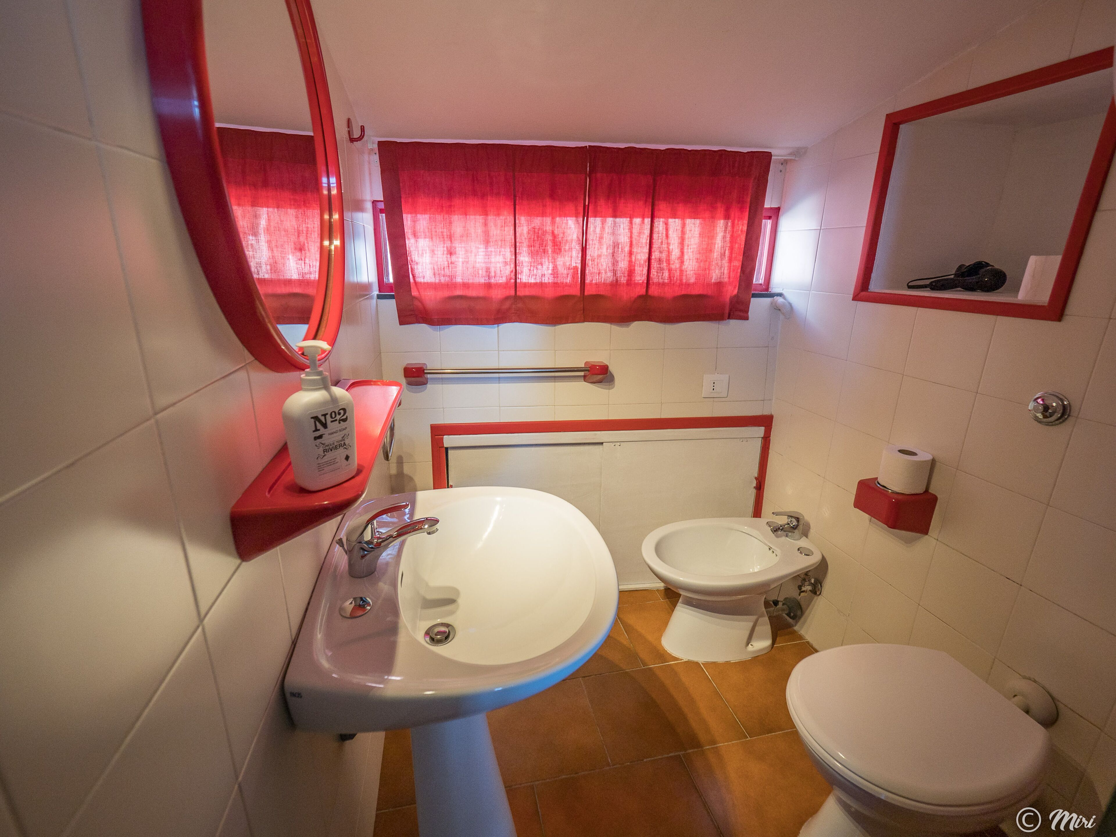 Une salle de bain équipée d’un lavabo, d’un bidet, de toilettes et d’un miroir.