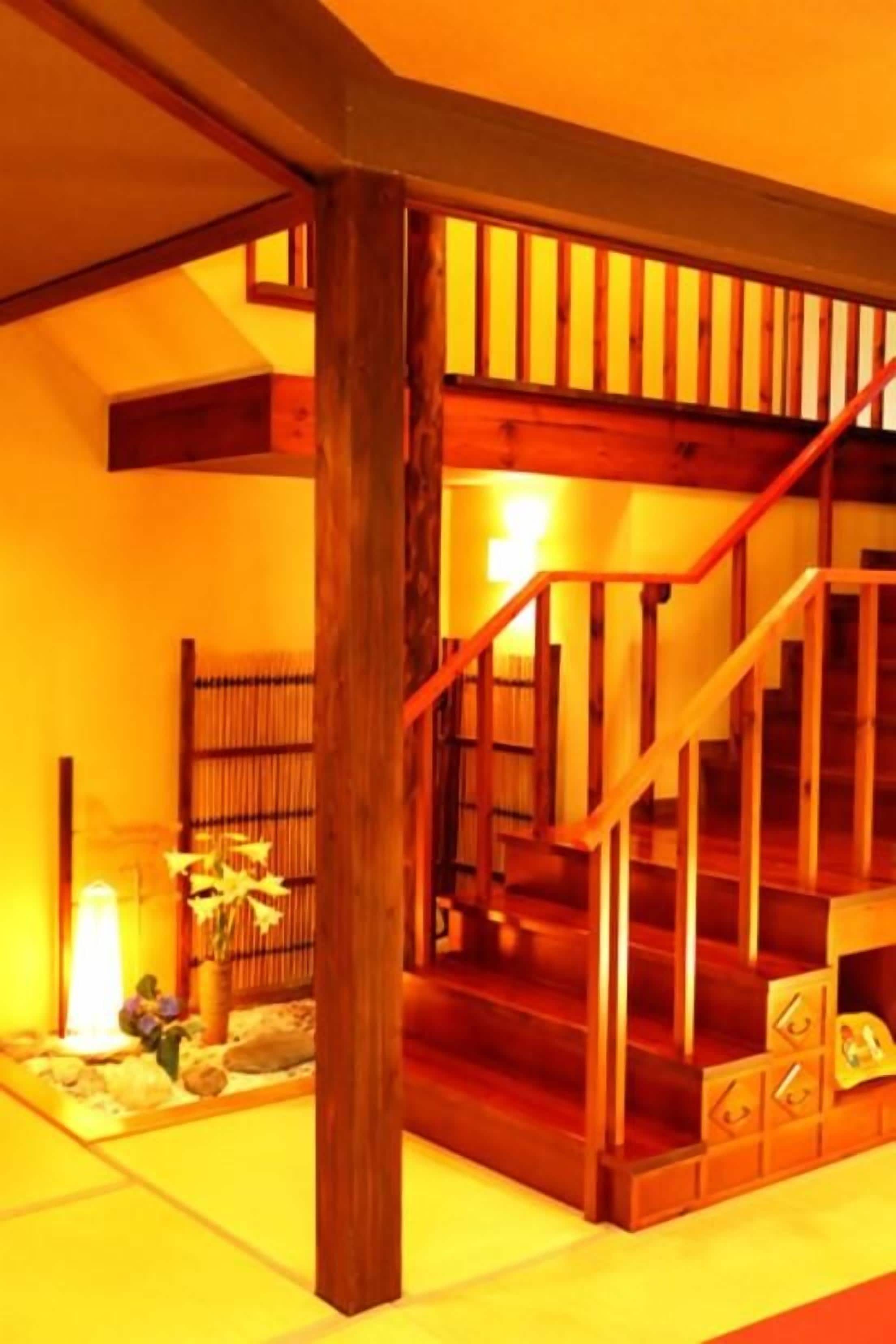 A wooden staircase with a handrail, leading to an upper floor.