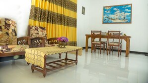A room with a dining table, chairs, a sofa, and a curtain. - senu villa (Bope-Poddala)