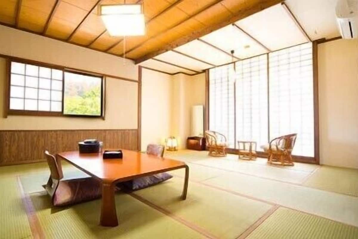 A traditional Japanese-style room with tatami flooring, a low wooden table, and shoji screens.