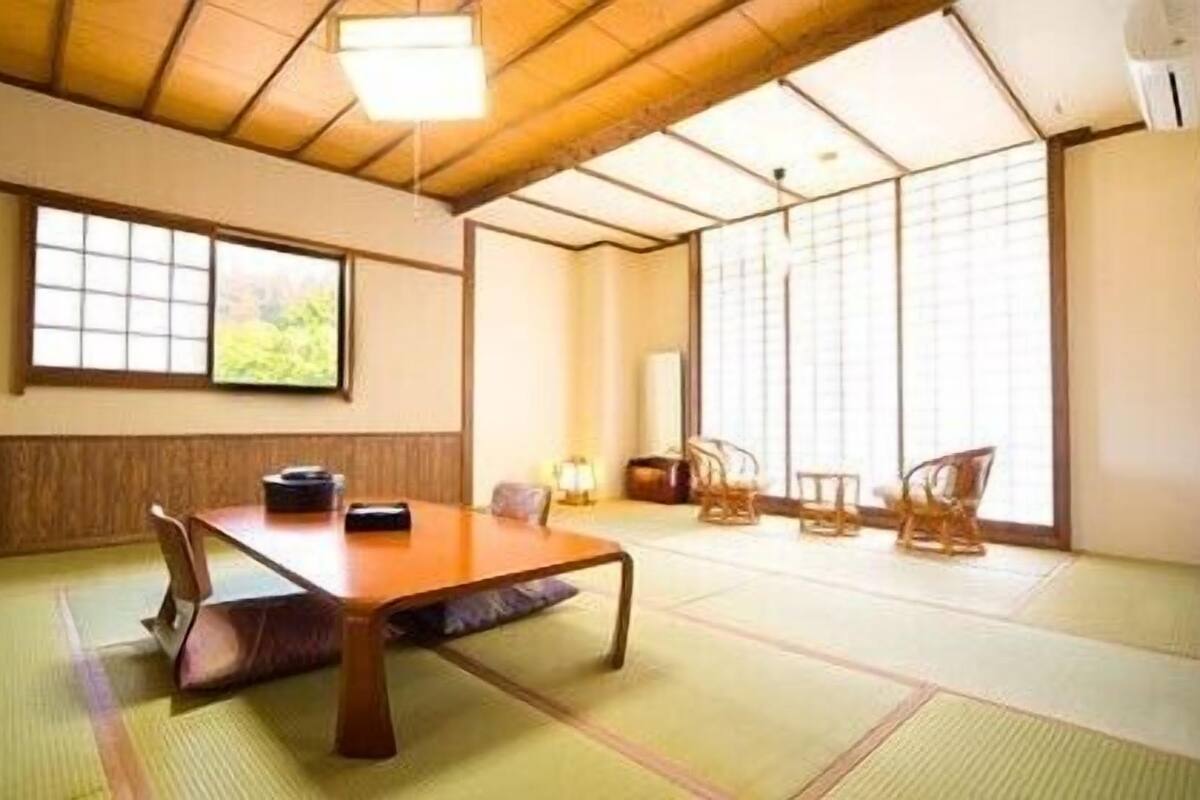 Een traditionele Japanse kamer met tatami vloerbedekking, een lage houten tafel en shoji schermen.