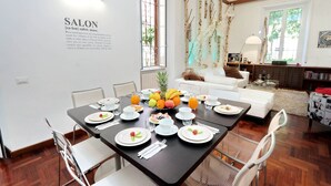A dining area with a table set for breakfast, including plates, cutlery, and a fruit bowl. - MONTEVERDE GUESTHOUSE: Spacious Villa in Rome Center ! (Roma)