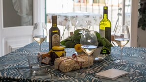 A table set with wine glasses, bottles, and food items, with a view of buildings through a window. - Recanissu Apartment with Balcony & AC (Vernazza)