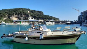 A boat docked at a marina with a mountainous backdrop. - Recanissu Apartment with Balcony & AC (Vernazza)