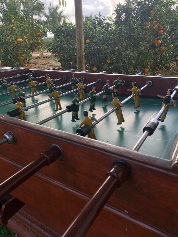 A foosball table with miniature figures in green and yellow uniforms.