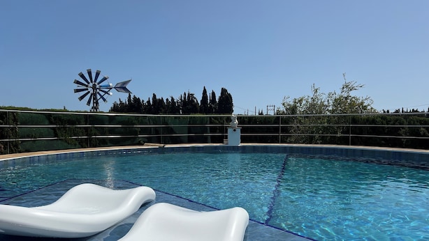 Une piscine dotée de deux toboggans à eau et d’un moulin à vent en arrière-plan.