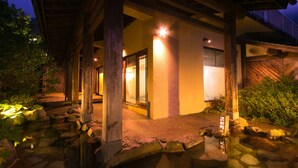 A traditional Japanese-style building with a stone pathway leading to a wooden entrance. - Kuju Kanko Hotel (Kokonoe)