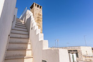 A white staircase leading up to a building with a stone tower. - Mare, mare, mare - Le Case di Valentina (Gallipoli)