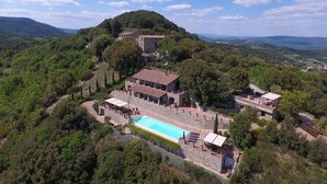 A villa with a swimming pool surrounded by lush greenery and hills. - the best location in the Maremma for maremmaguide (pari)