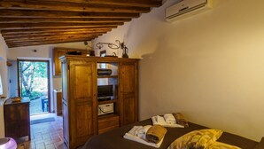 A cozy room with a bed, a wooden wardrobe, and a small table with a bowl. - the best location in the Maremma for maremmaguide (pari)