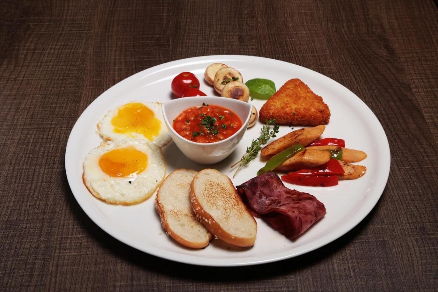 Ein Teller mit Frühstücksessen, darunter Eier, Toast, Pilze und Gemüse.