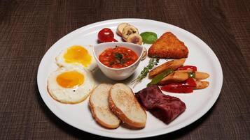 Ein Teller mit Frühstücksessen, darunter Eier, Toast, Pilze und Gemüse.