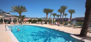 A swimming pool with lounge chairs and palm trees. - Brand new villa near all mayor themeparks & airport. Private jacuzzi & Pool ! (Kissimmee)