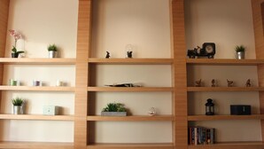 Una estantería de madera con diversos objetos decorativos y plantas.