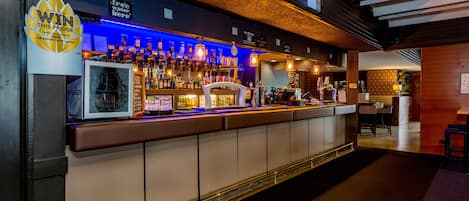 A bar with a long counter, shelves of bottles, and a sign reading "WIN THIS FRIDGE."